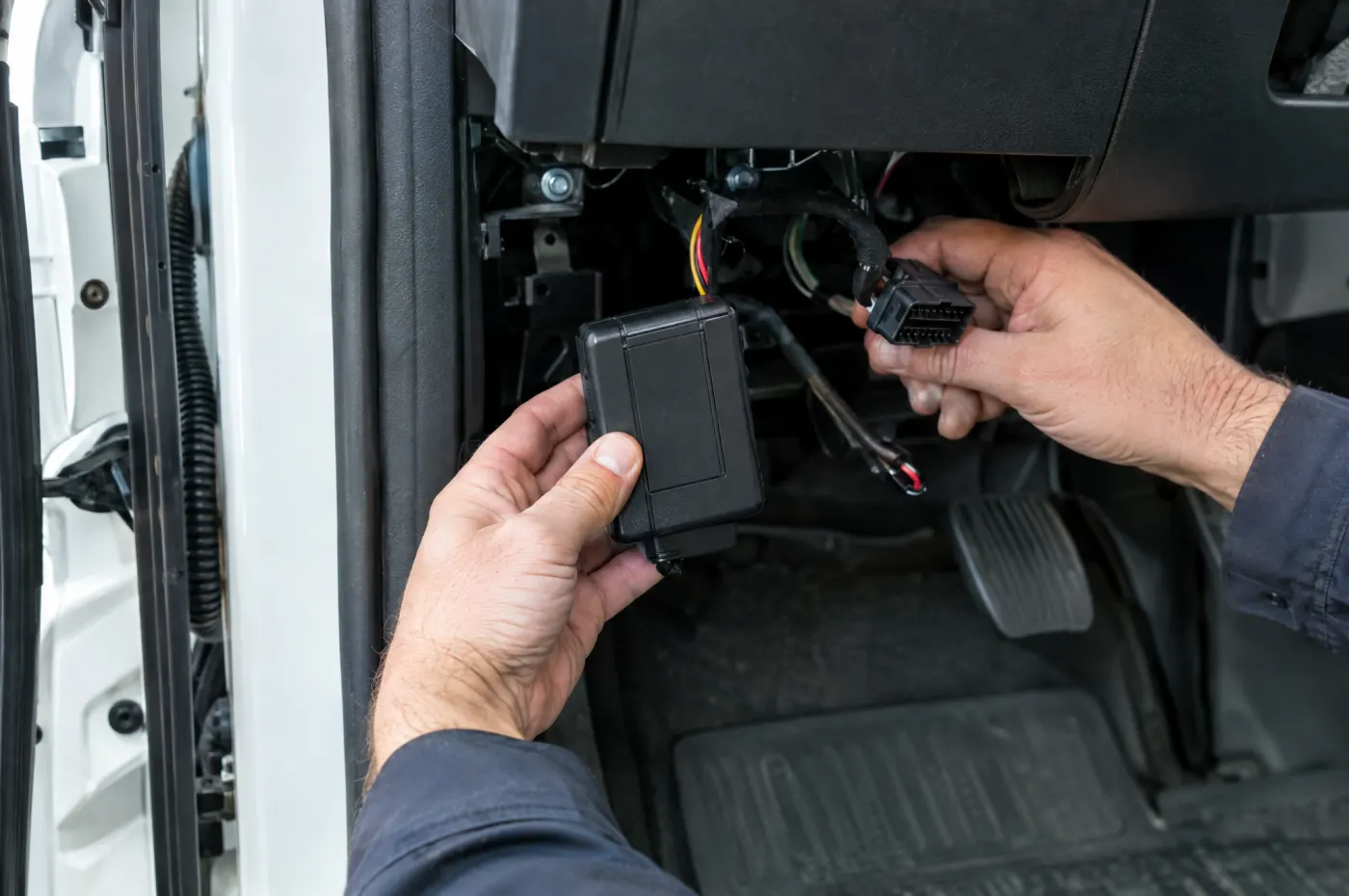 Einbau eines GPS-Trackers unter dem Armaturenbrett eines Transporters